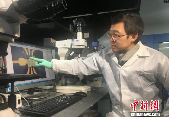南京大学教授缪峰向记者介绍这种新结构电子元件的抗热原理。 申冉 摄